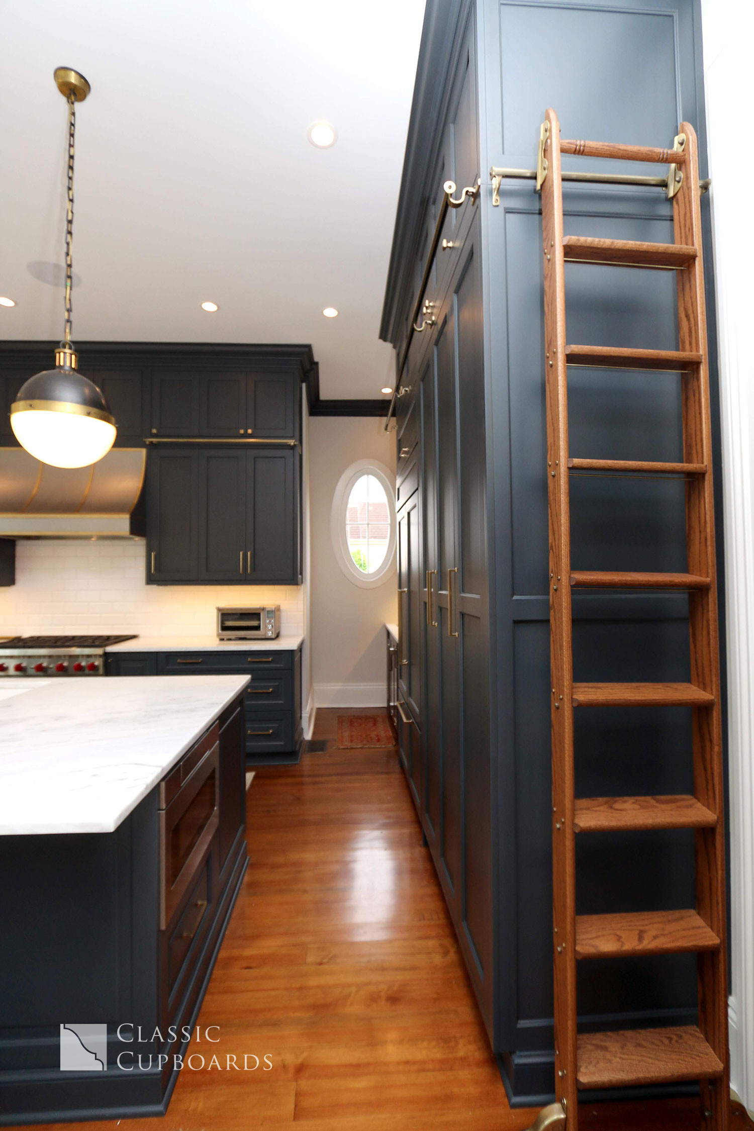 navy blue cabinets with library ladder