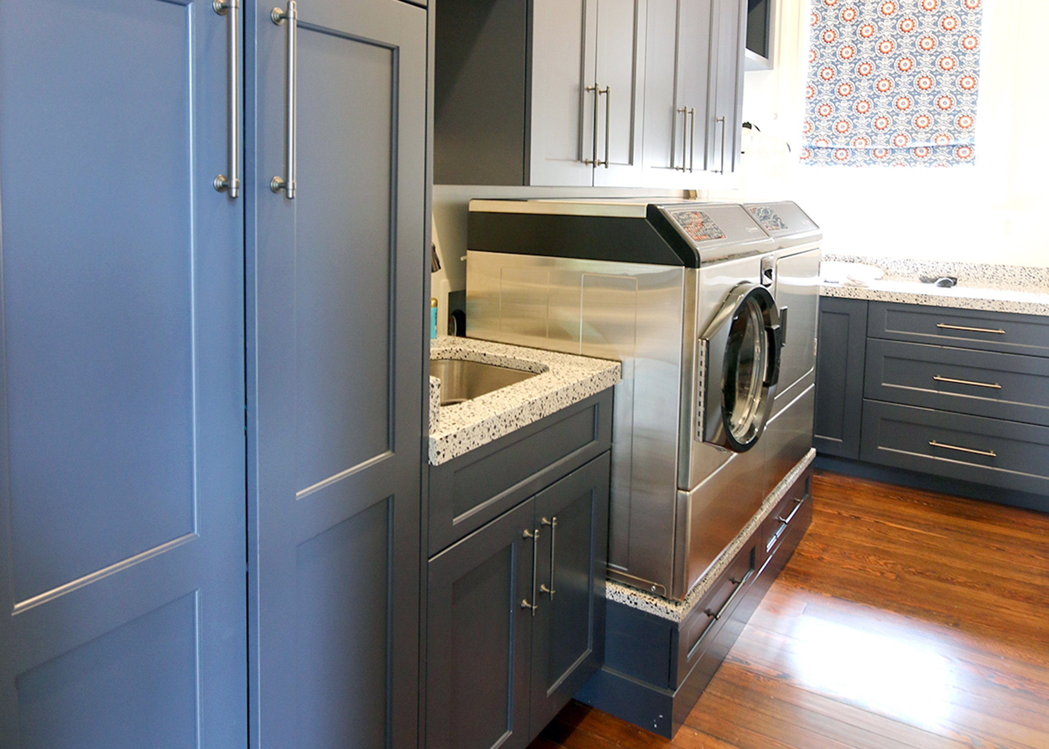 custom laundry room with blue cabinets